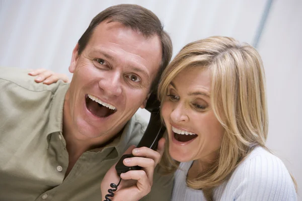 Casal recebendo boas notícias pelo telefone — Fotografia de Stock