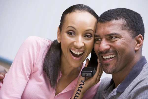 Casal recebendo boas notícias por telefone — Fotografia de Stock