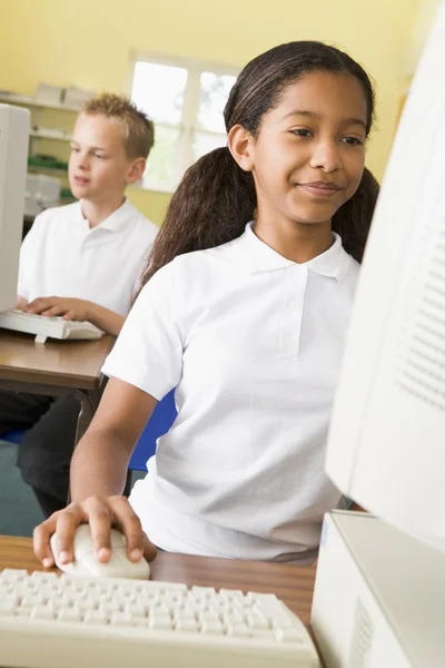 Colegiala estudiando delante de una computadora escolar — Foto de Stock