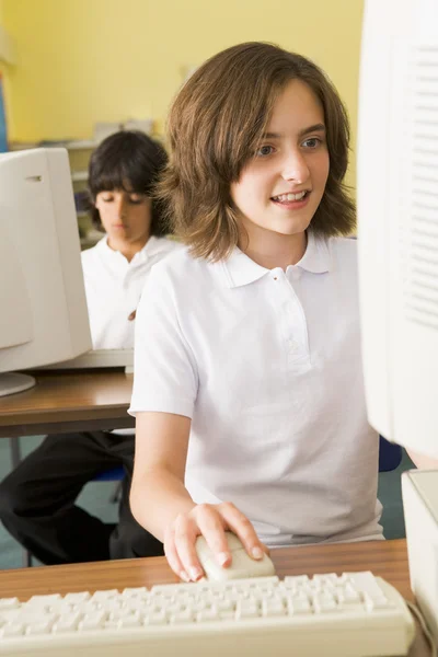 Colegiala estudiando delante de una computadora escolar — Foto de Stock