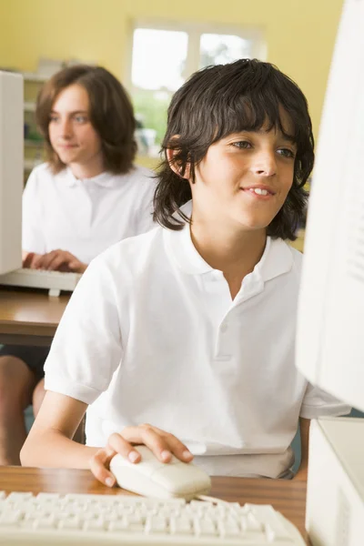 Школярка навчається перед шкільним комп'ютером — стокове фото
