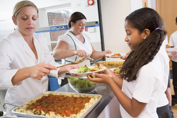 Schoolgirl holding plate of lunch in school cafeteria — Stock Photo, Image