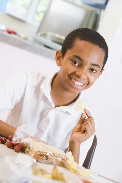 Skolpojke njuter av sin lunch i en skolmatsal — Stockfoto
