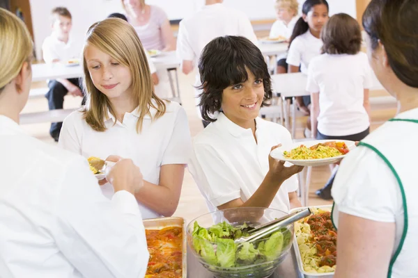 午餐女士在学校餐厅供应午餐盘 — 图库照片