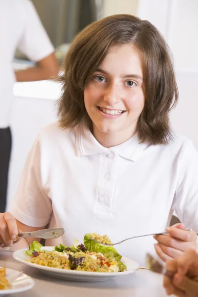 Schoolmeisje geniet van haar lunch in een school cafetaria — Stockfoto