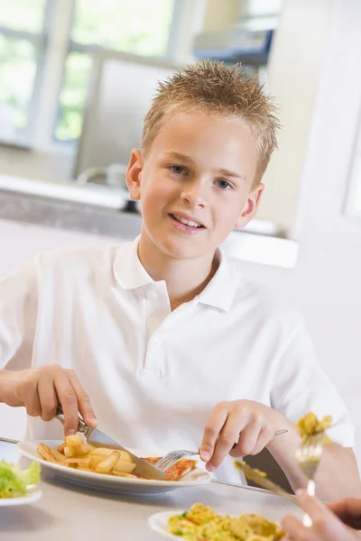 一个男孩在学校的自助餐厅里吃午饭 — 图库照片