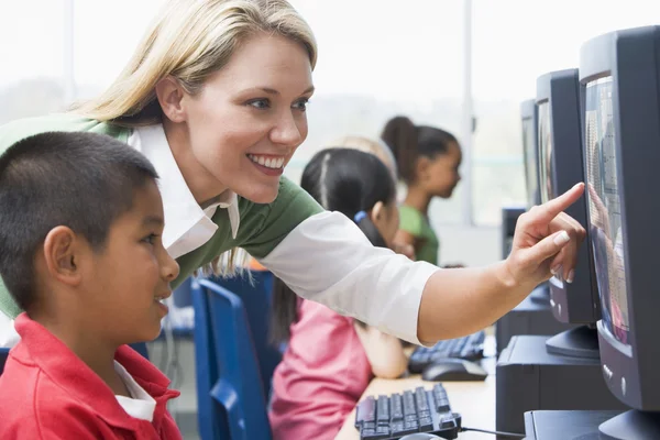 Profesor ayudando a los niños del jardín de infantes a aprender a usar computadoras —  Fotos de Stock
