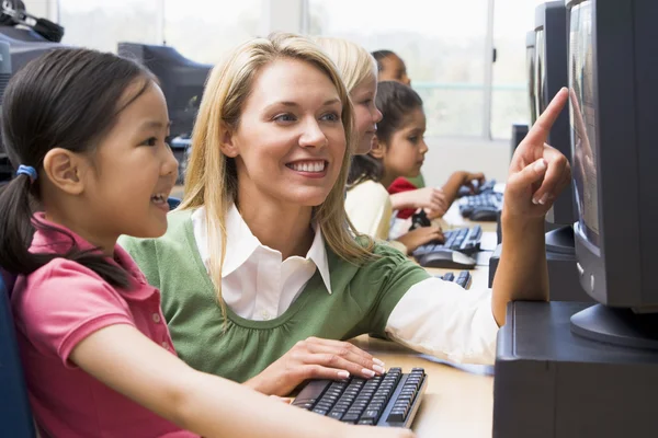 Profesor ayudando a los niños del jardín de infantes a aprender a usar computadoras —  Fotos de Stock