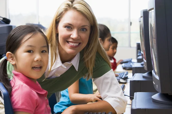 Profesor ayudando a los niños del jardín de infantes a aprender a usar computadoras — Foto de Stock