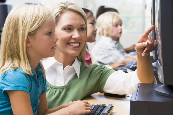 Leraar helpen kleuterschool kinderen leren hoe computers te gebruiken — Stockfoto