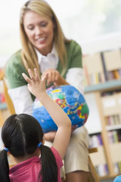 Professor de jardim de infância e crianças olhando para o globo — Fotografia de Stock