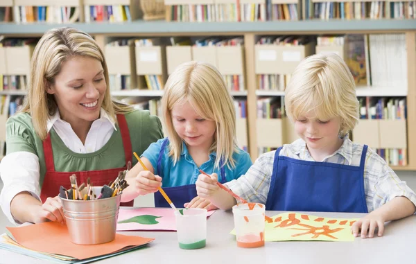 Professora de jardim de infância sentada com alunos em aula de arte — Fotografia de Stock