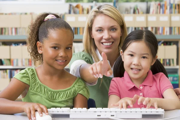 Nauczyciel przedszkola siedzący z dziećmi na komputerze — Zdjęcie stockowe