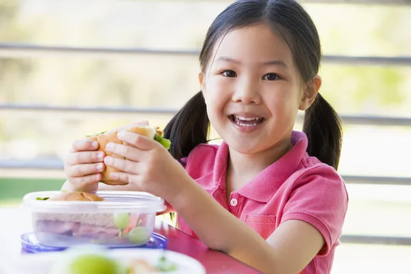 Dívka jíst oběd ve školce — Stock fotografie