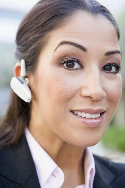 Kobieta za pomocą bluetooth słuchawka — Zdjęcie stockowe