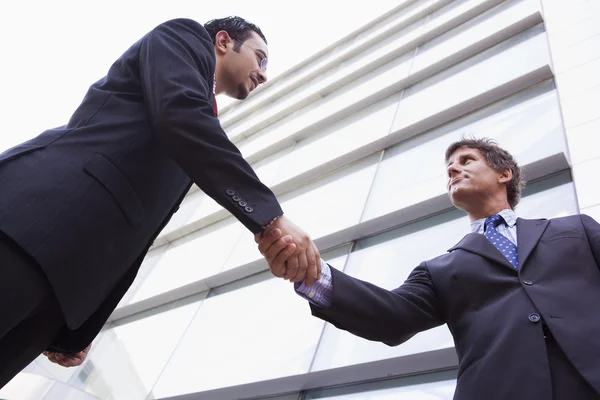 Des hommes d'affaires serrent la main devant un immeuble de bureaux — Photo
