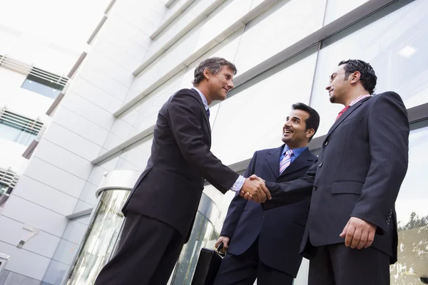 Группа бизнесменов пожимает руки за пределами офиса — стоковое фото