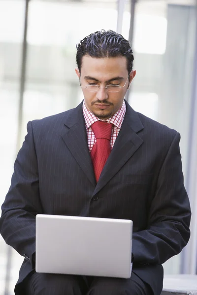 Empresário usando laptop fora — Fotografia de Stock