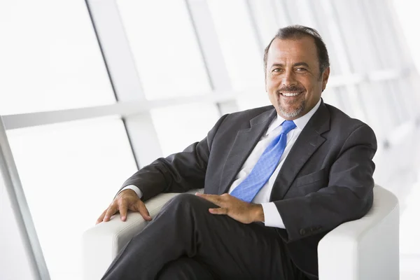 Businessman relaxing in lobby — Stock Photo, Image