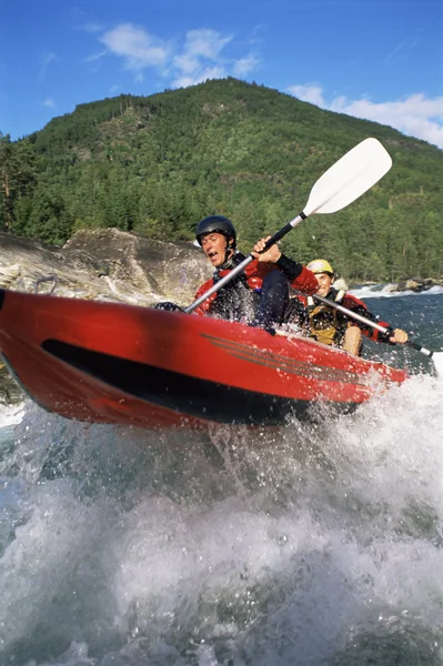 Two paddling inflatable boat down rapids Royalty Free Stock Photos