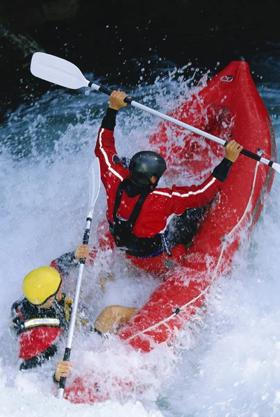 Two paddling inflatable boat down rapids Royalty Free Stock Images
