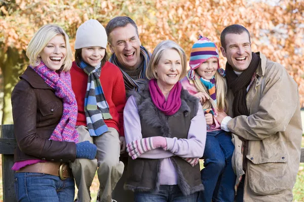 秋季多代家庭步行坐在栅栏上 免版税图库照片