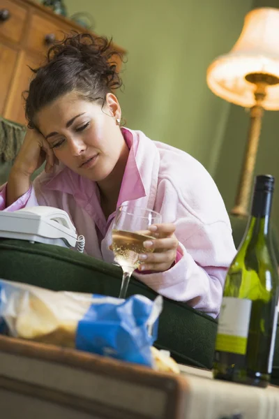 A young woman in her pyjamas drinking wine and watching her tele — Stock Photo, Image