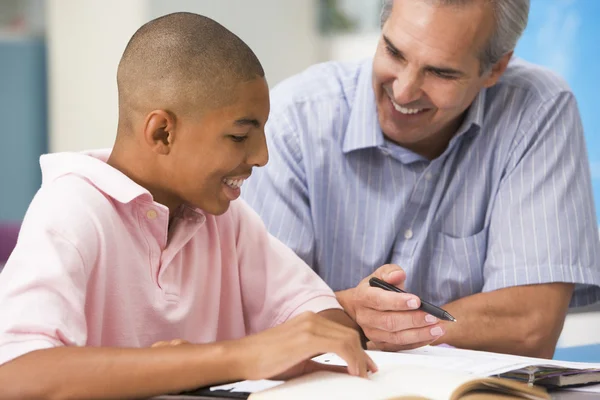 A teacher instructs a schoolboy in a high school class Royalty Free Stock Images