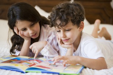 A Middle Eastern brother and sister reading together clipart