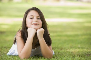 Girl relaxing in park clipart