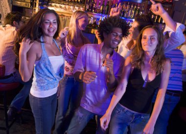 Young men and women dancing in a nightclub clipart