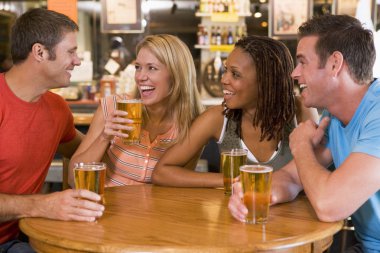 Group of young friends drinking and laughing in a bar clipart