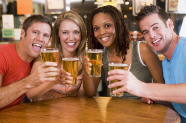 Group of young friends in bar toasting the camera clipart