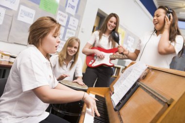 Schoolgirls playing musical instruments in music class clipart