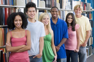 Group of six students standing in front of library bookshelves clipart