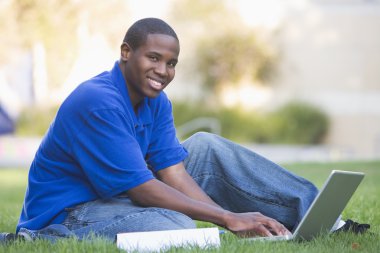 University student using laptop outside clipart