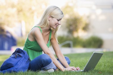 University student using laptop outside clipart