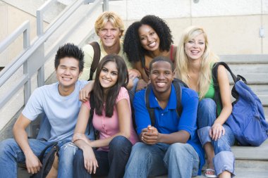 Group of six students outside sitting on steps clipart