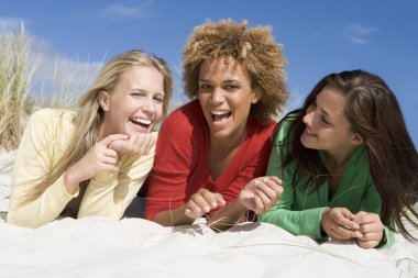 Three friends having fun at beach clipart