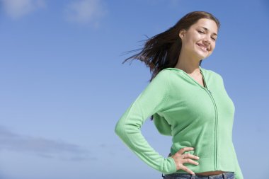 Portrait of young woman against blue sky clipart