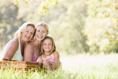 Grandmother with adult daughter and grandchild on picnic clipart