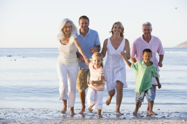 Extended family walking on beach clipart