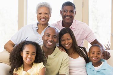 Extended family sitting on sofa clipart