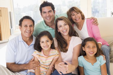 Extended family in living room smiling clipart