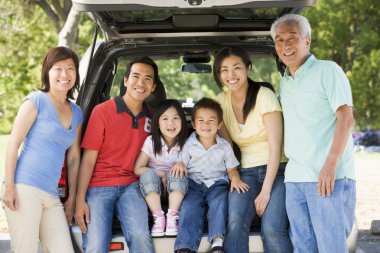 Extended family sitting in tailgate of car clipart