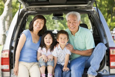 Grandparents with grandkids in tailgate of car clipart
