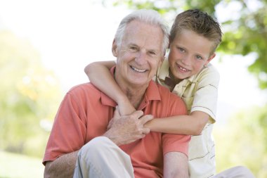 Grandfather and grandson outdoors smiling clipart