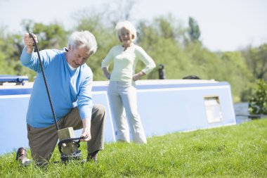 Couple outdoors by lake with boat clipart