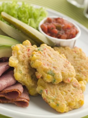 Sweet corn Fritters with Salsa Gherkins Avocado and Pastrami clipart