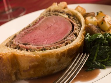 Slice of Beef Wellington with Spinach and Saut ed Potatoes clipart